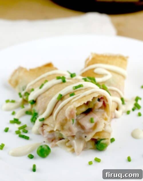 Savory Ham, Pea, and Cheese Crepes 2 Golden brown Ham, Peas, and Cheese Crepes arranged elegantly on a serving dish, ready to be enjoyed.