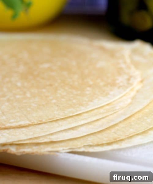 Savory Ham, Pea, and Cheese Crepes 5 A serving of Ham, Peas, and Cheese Crepes drizzled with a creamy Dijon sauce, ready to be served.