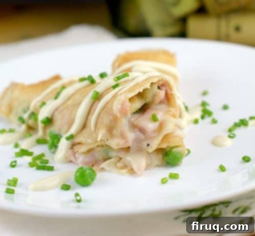 Savory Ham, Pea, and Cheese Crepes 10 Close-up of a serving of Ham, Peas, and Cheese Crepes with a focus on the rich, creamy sauce.