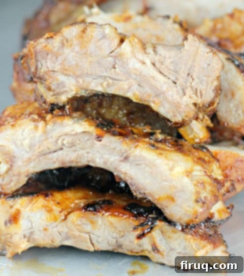 Brewmaster's Baby Back Ribs 9 Hand holding a piece of perfectly cooked Beer Barbecue Baby Back Rib