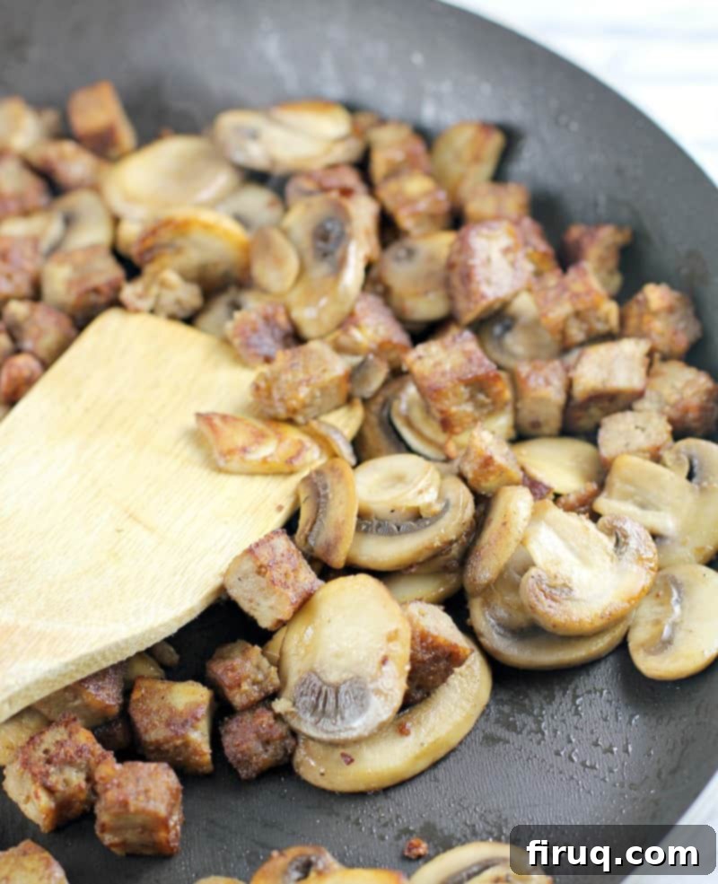 Plant-Powered Omelet with Savory Sausage, Spinach, and Mushrooms 6 sauteed mushrooms and sausage in a skillet