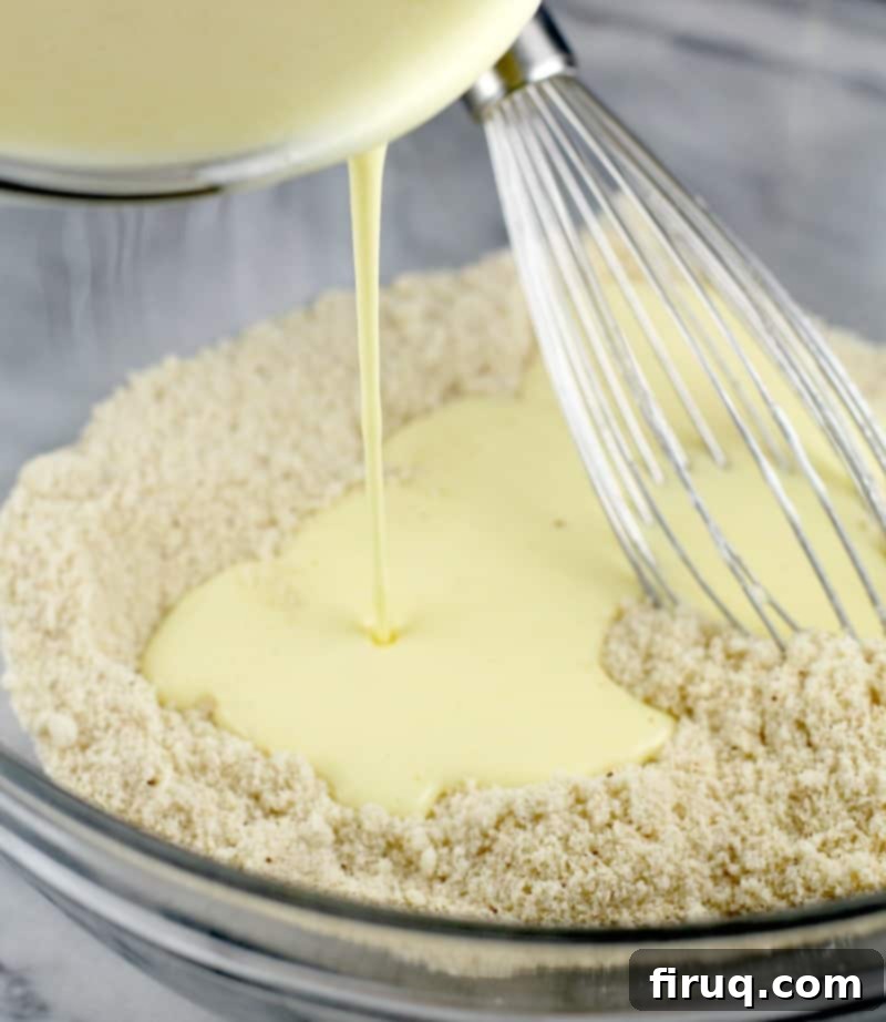 Guilt-Free Cheddar Bay Biscuits 6 Pouring wet ingredients into a bowl of dry ingredients for the biscuit batter