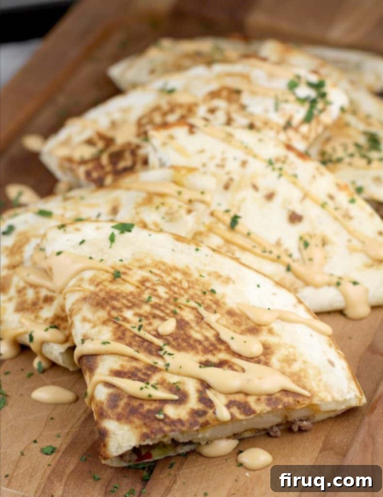 Loaded Burger Fry Quesadilla 13 top/angle view of finished quesadilla on a wood serving plate to show how to serve them