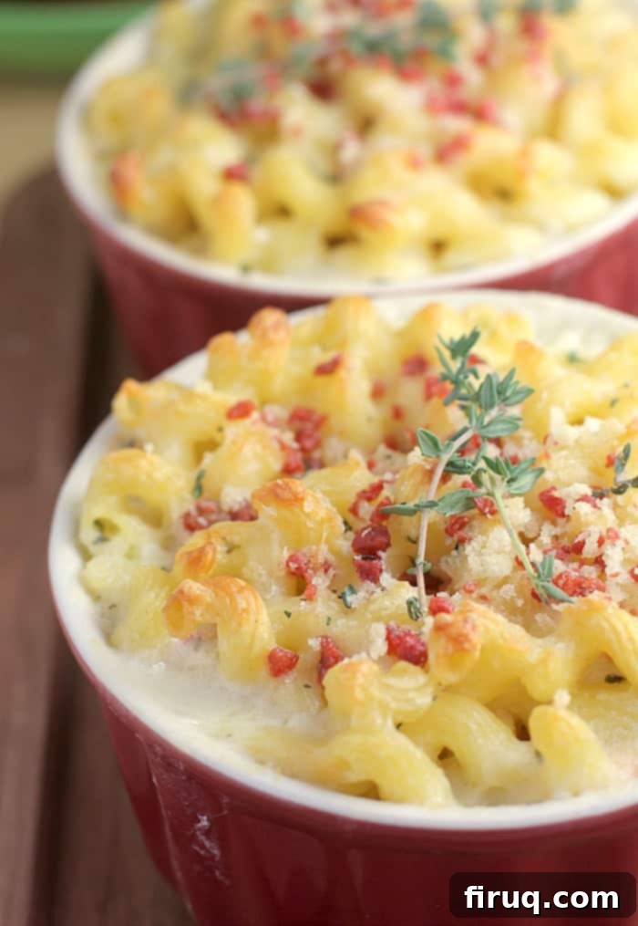 Gourmet White Wine Mac and Cheese 8 a red crock filled with macaroni and cheese topped with bacon and a tiny sprig of thyme; a second crock is in the background