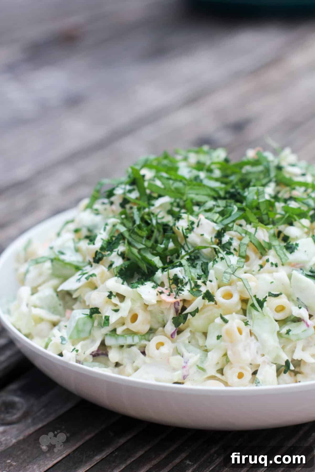 Creamy Slaw Macaroni Medley 5 Close-up, angle view of macaroni coleslaw salad in a white bowl
