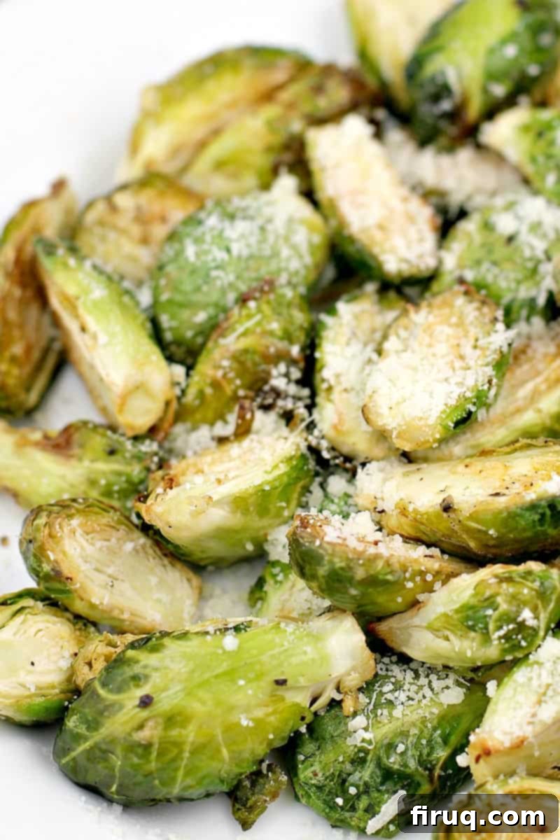 Crispy Air-Fried Brussels Sprouts 3 Close-up view of the finished air-fried Brussels sprouts generously topped with freshly grated Parmesan cheese.