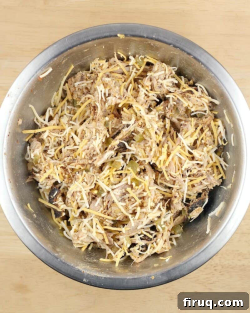 Crispy Air Fryer Pulled Pork Taquitos 5 pulled pork taquito filling in a metal mixing bowl