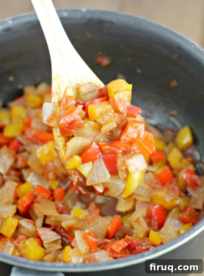 Air Fryer Hot Dogs: Crispy Perfection with Sweet Pepper Relish 6 spoon scooping sweet pepper relish in a black saucepan
