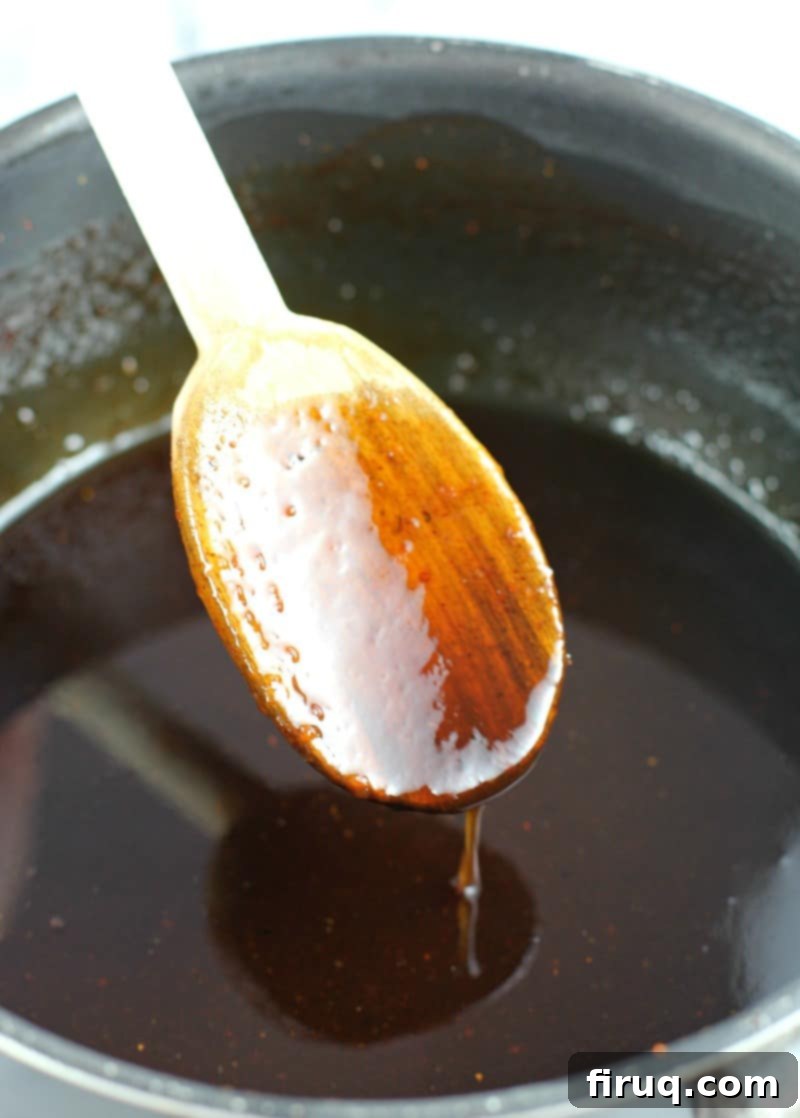 Sweet & Smoky Maple Bourbon Chicken 4 spoon with maple bourbon glaze dripping off