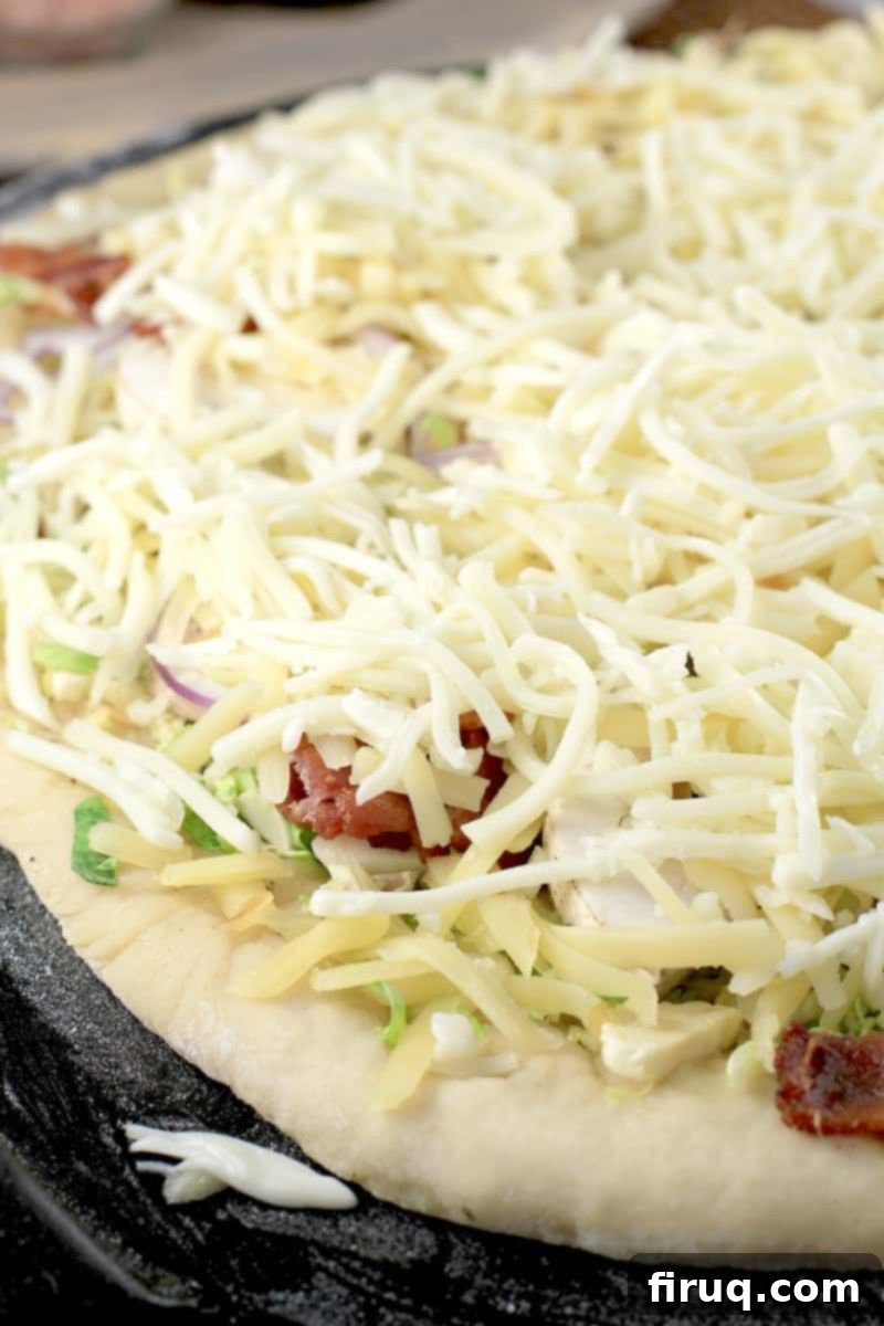 Crispy Bacon & Roasted Brussels Pizza 6 cheeses layered on pizza before cooking