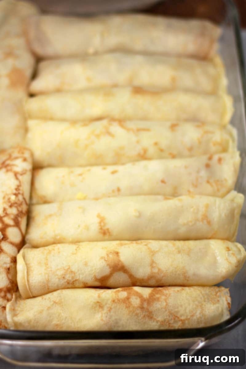 Creamy Béchamel Ham and Cheese Breakfast Crepes 8 assembled crepes in pyrex bake dish before cooking