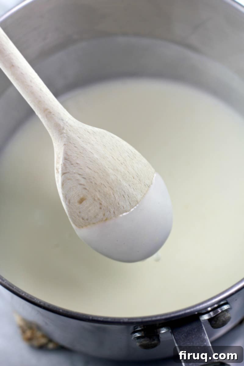 Creamy Béchamel Ham and Cheese Breakfast Crepes 9 back of wooden spoon with bechamel sauce