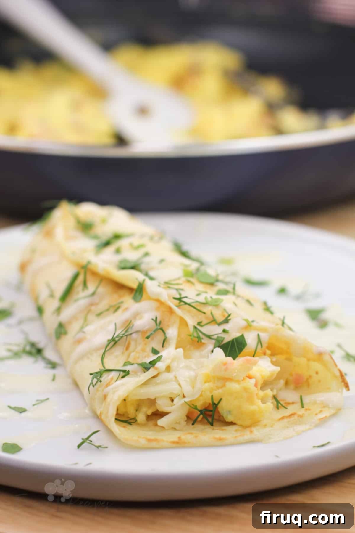 Silken Salmon Crepe Embrace 2 prepared smoked salmon crepe on white dish. skillet in the background
