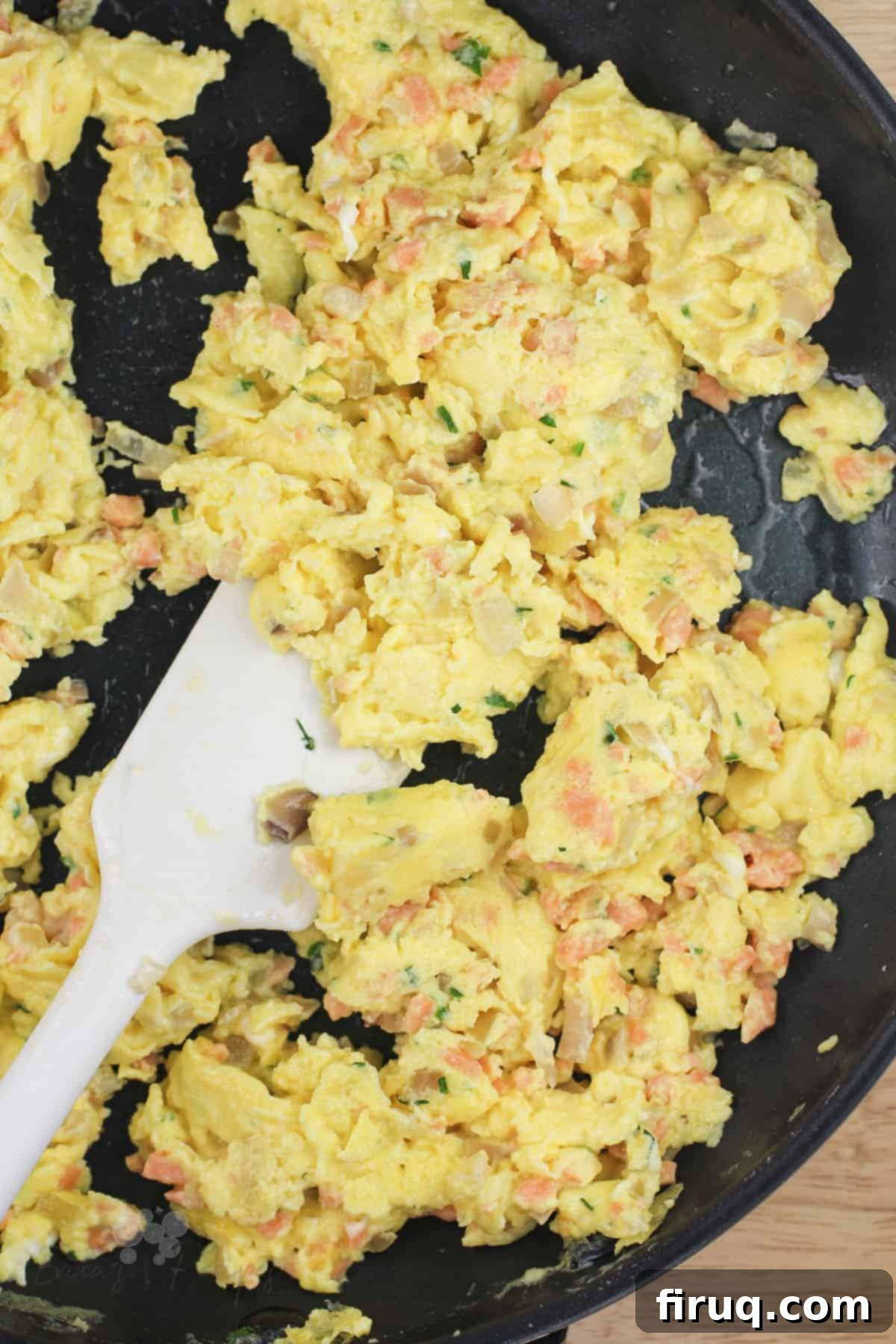 Silken Salmon Crepe Embrace 8 scrambled eggs with smoked salmon in skillet with white rubber spatula