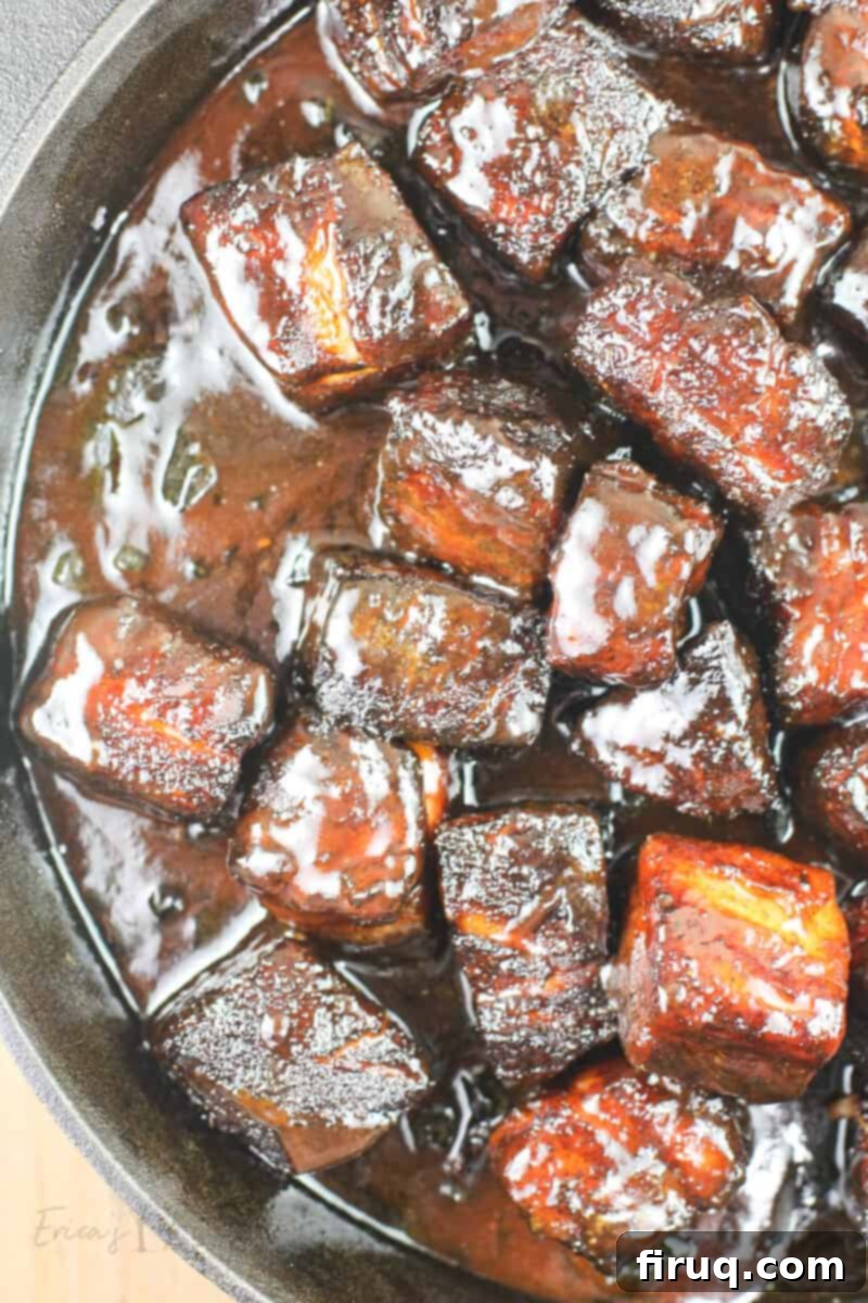 Smoky Glazed Pork Belly Bites 3 Close-up of glazed pork belly burnt ends in a black pan, showcasing their sticky texture