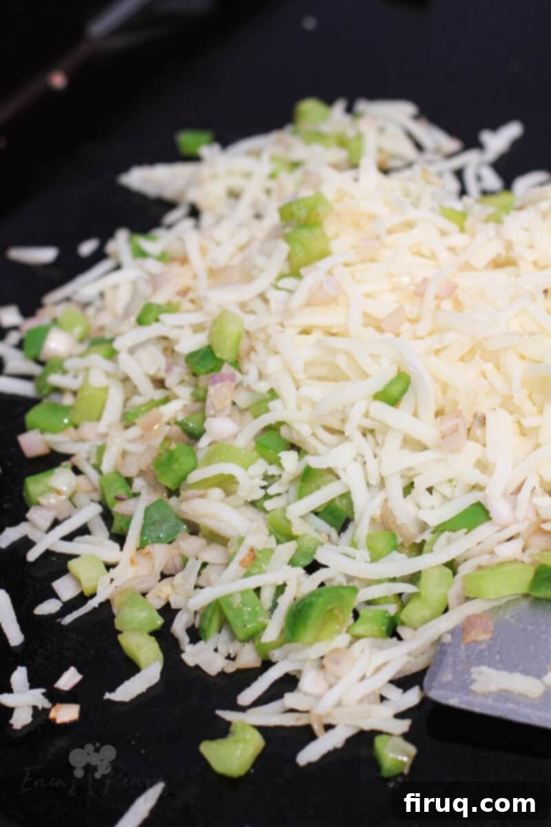 Sizzling Griddle Hash 4 raw potato and bell pepper on black griddle surface