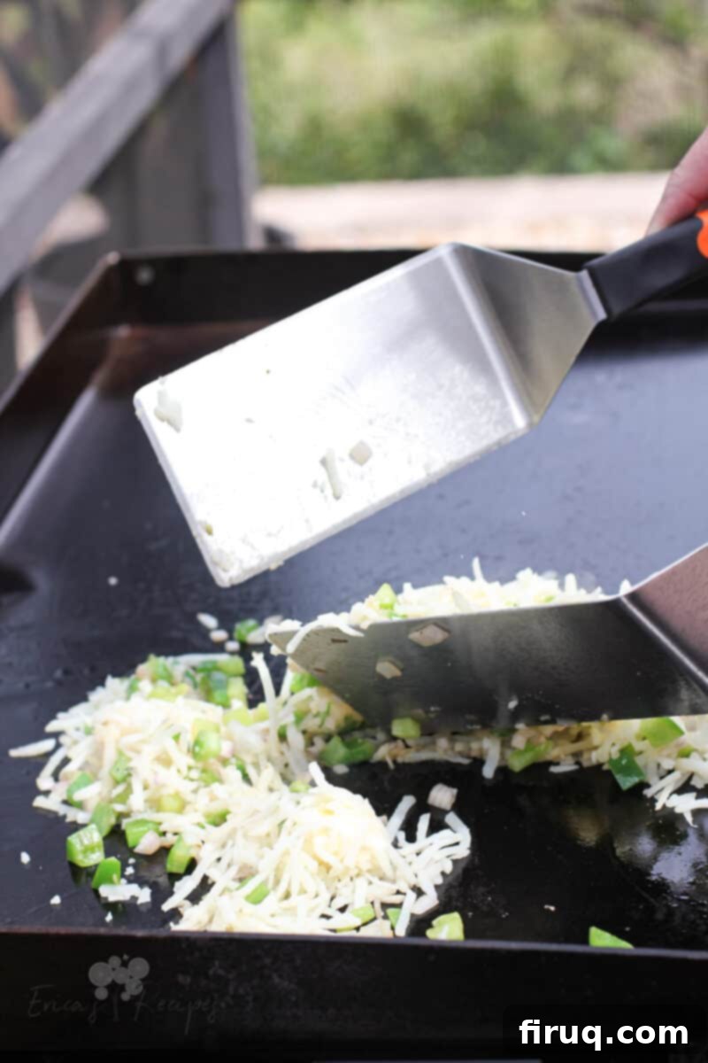 Sizzling Griddle Hash 5 2 spatulas tossing hash browns on Blackstone griddle