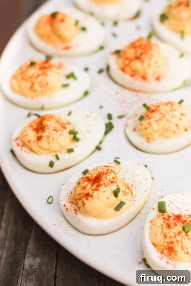 Zesty Stuffed Eggs 8 prepared deviled eggs topped with chives on a white serving platter