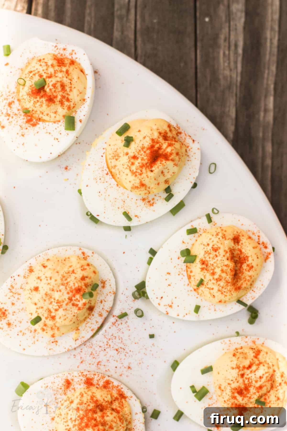 Zesty Stuffed Eggs 9 top down view of deviled eggs topped with chives on a white serving platter