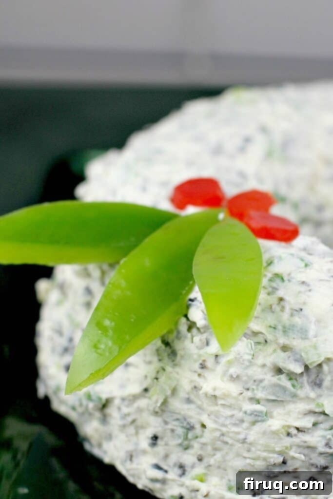 Festive Olive & Scallion Wreath Dip 4 Detailed side view of the Scallion Olive Party Dip cheese wreath, showcasing the creamy texture and vibrant red and green bell pepper accents.