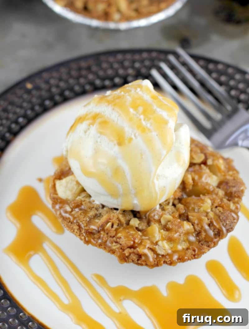 Individual Apple Crisp Pies 3 close view of mini apple crisp tart on a plate topped with ices cream and caramel