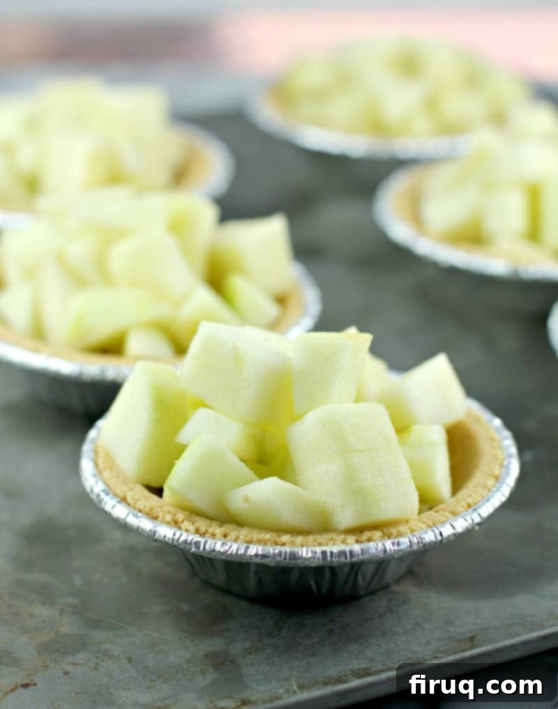 Individual Apple Crisp Pies 4 diced apple in a mini graham cracker tart shell on a metal sheet