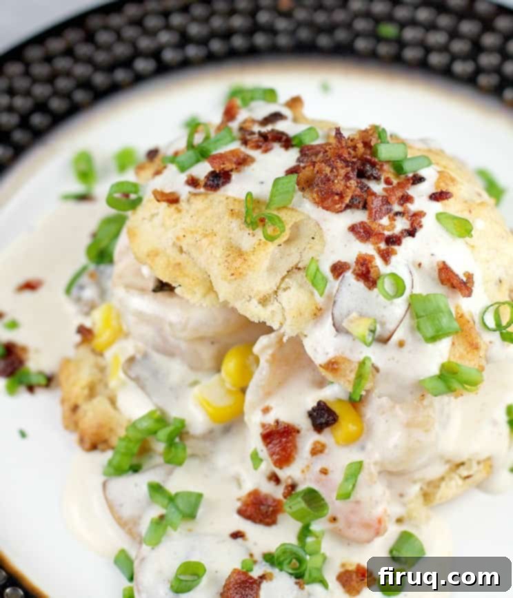 Cheddar Bay Bacon Biscuits Smothered in Shrimp Gravy 2 biscuit on plate topped with gravy with shrimp, corn and bacon