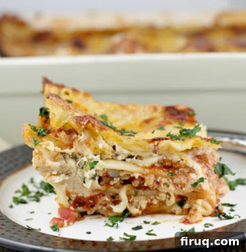 Classic Lasagna 12 squared off side view showing the layers for the best lasagna ever with the rest of the casserole in the background
