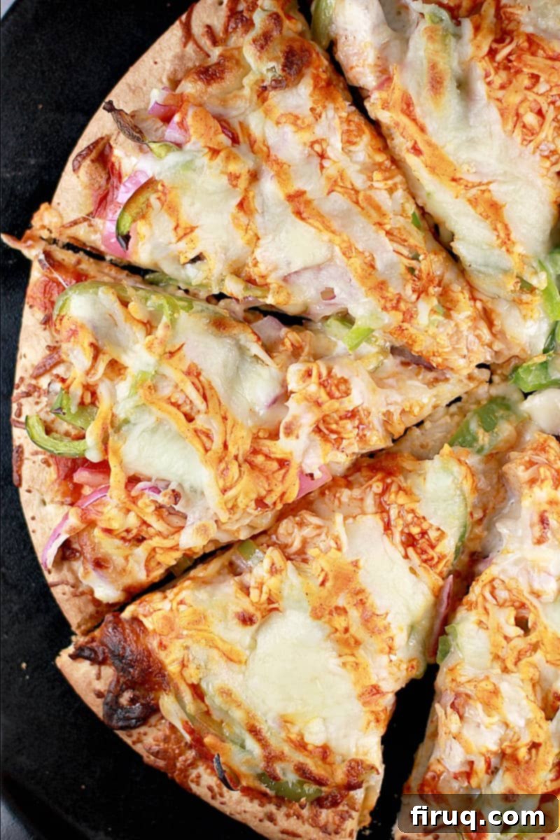 Spicy Buffalo Turkey Pizza 3 Top down view of this easy recipe with turkey; the finished pizza showing half of the sliced pizza on a black pizza stone.