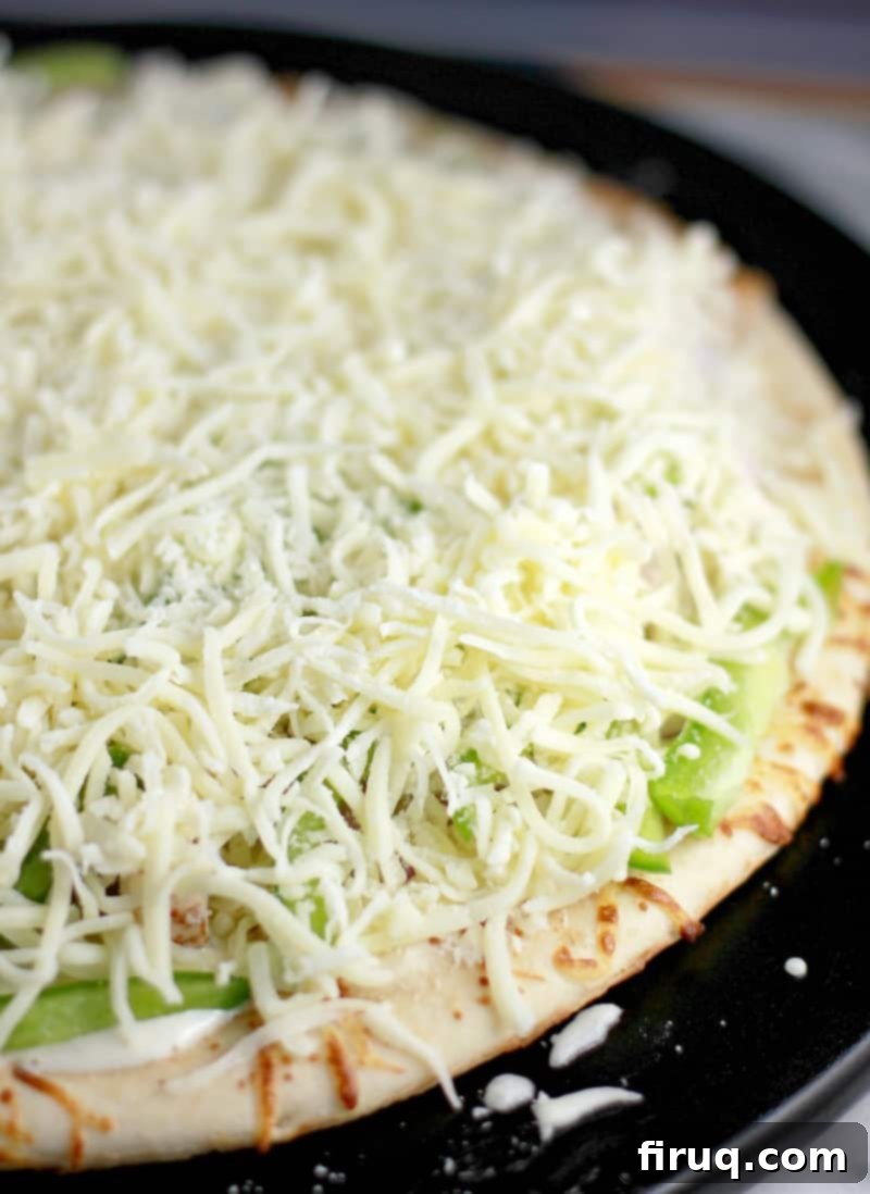 Spicy Buffalo Turkey Pizza 6 The uncooked pizza showing the layer of shredded mozzarella.