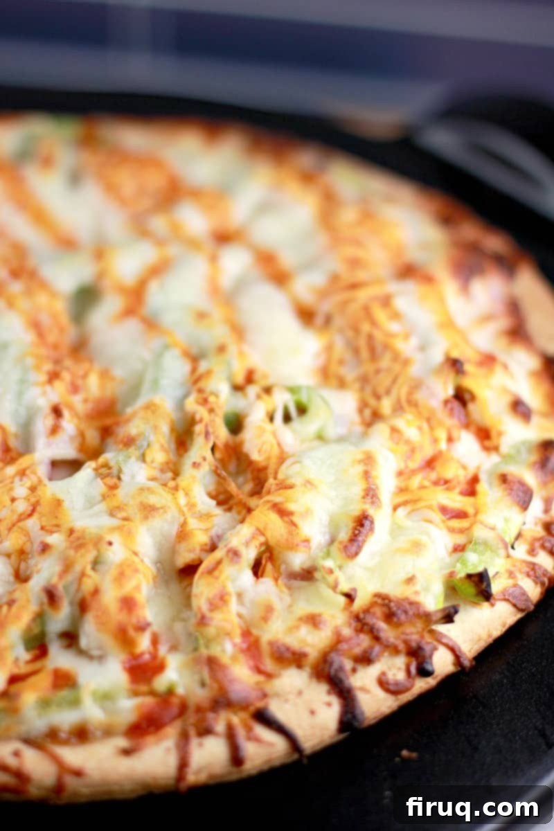 Spicy Buffalo Turkey Pizza 7 The cooked whole pizza showing the buffalo sauce drizzled over the melted cheese.