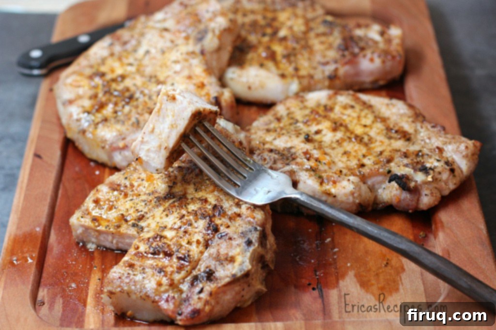 The Ultimate Grilled Pork Chops 2 Perfectly Grilled Pork Chops on a plate, ready to serve