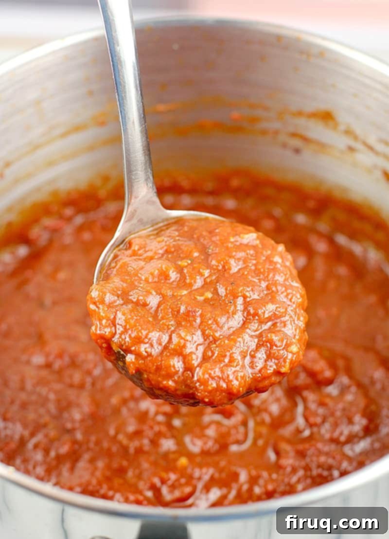 Perfect Homemade Pizza Sauce 3 ladle scooping up cooked sauce