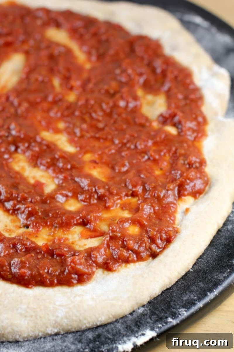 Perfect Homemade Pizza Sauce 7 sauce layered on pizza dough