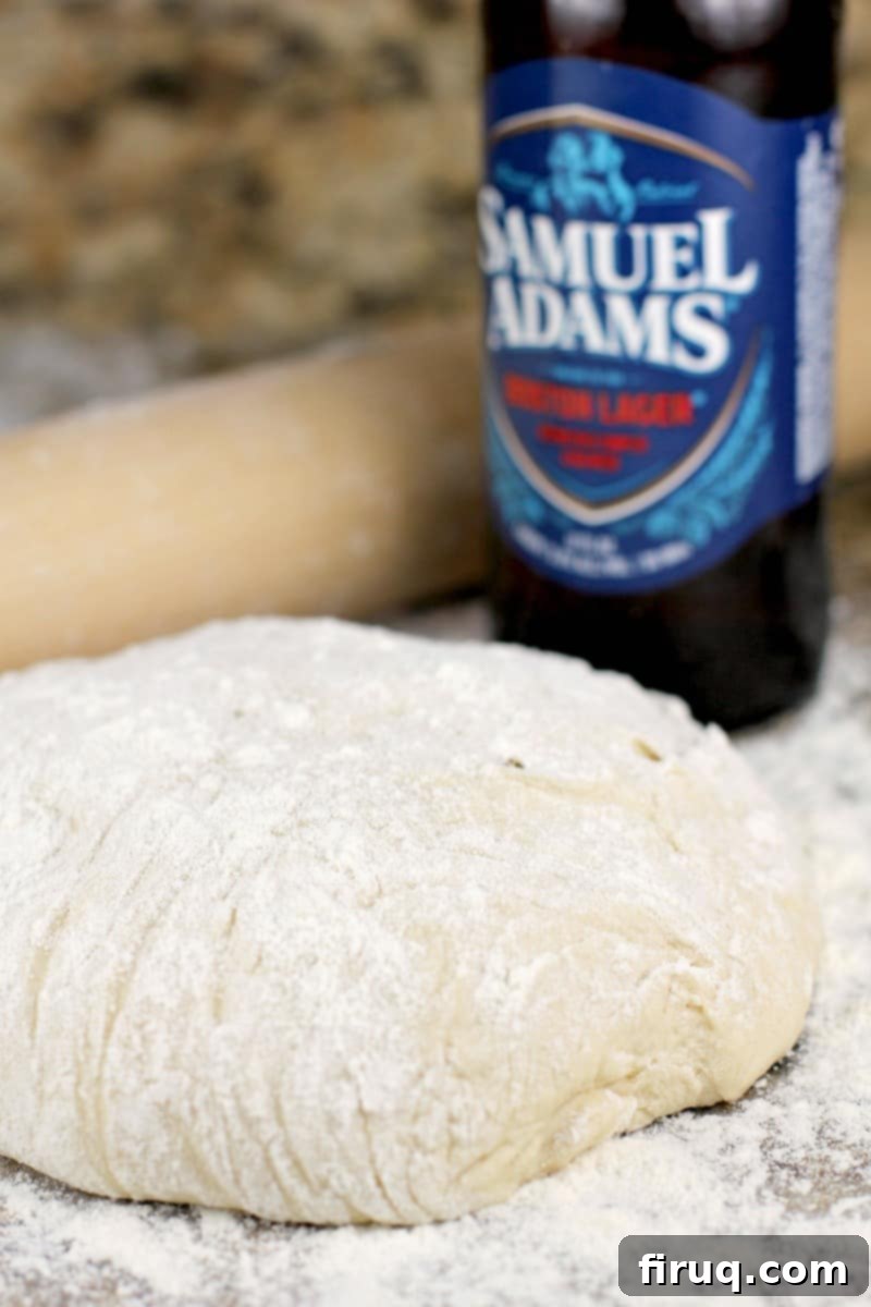 Sam Adams Hoppy Pizza Crust 2 homemade pizza dough on a granite surface with a rolling pin and sam adams beer bottle
