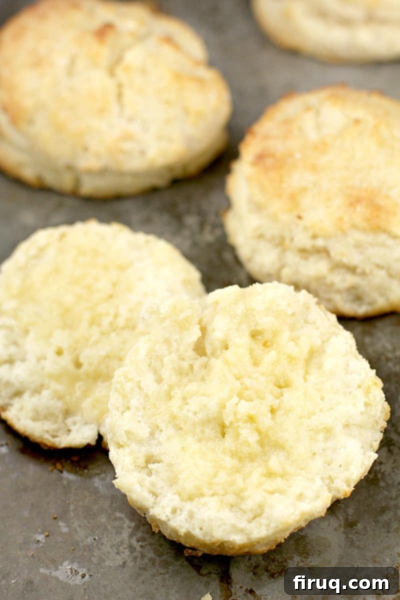 Fluffy Southern Buttermilk Biscuits 3 biscuit sliced in half with butter on it