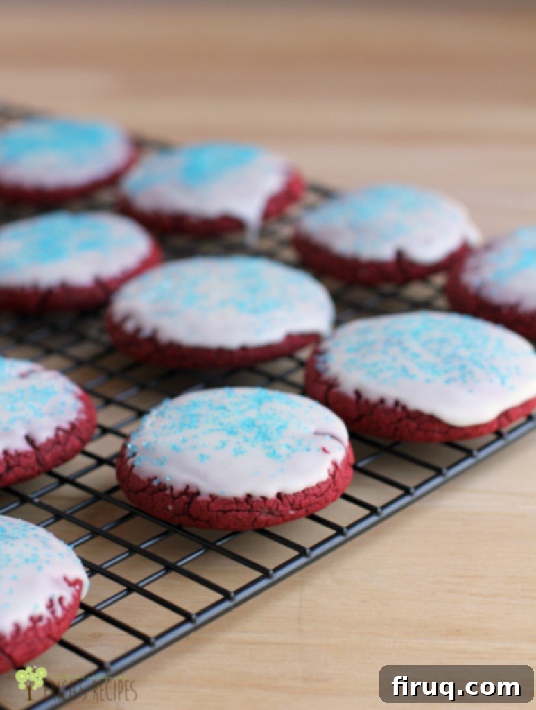 Irresistible Red Velvet Cake Mix Cookies 5 Close-up of Glazed Red Velvet Cake Mix Cookies with Blue Sprinkles on a Cooling Rack