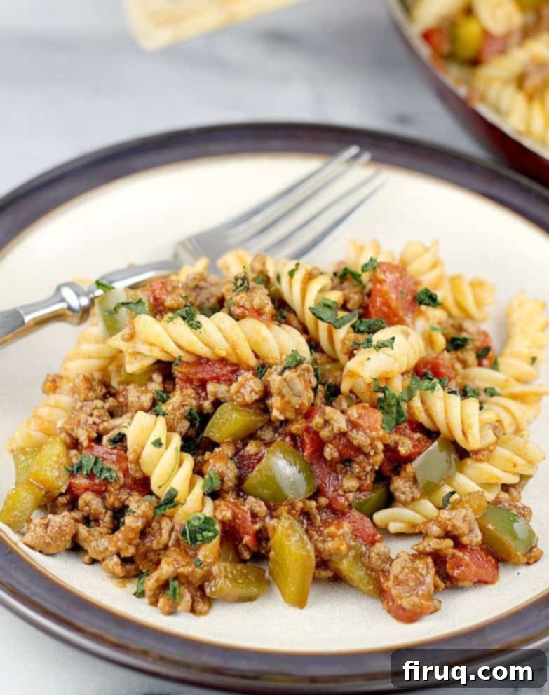 Homestyle Beef & Macaroni Bake 10 zoomed view of the sloppy joes on a plate with a fork, showcasing the texture of the meat and pasta
