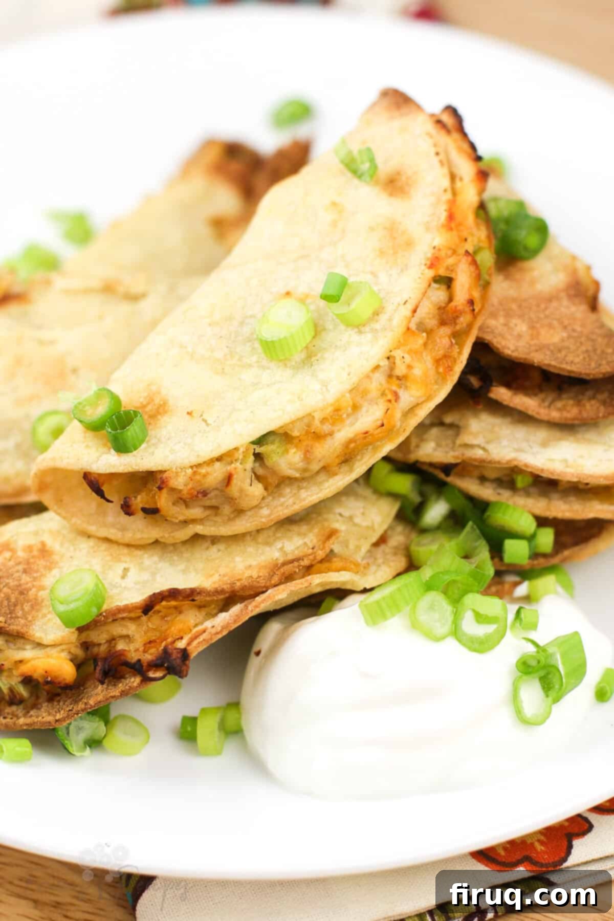 Crispy Mini Air Fryer Chicken Quesadilla 2 mini quesadilla on white plate topped with green onion