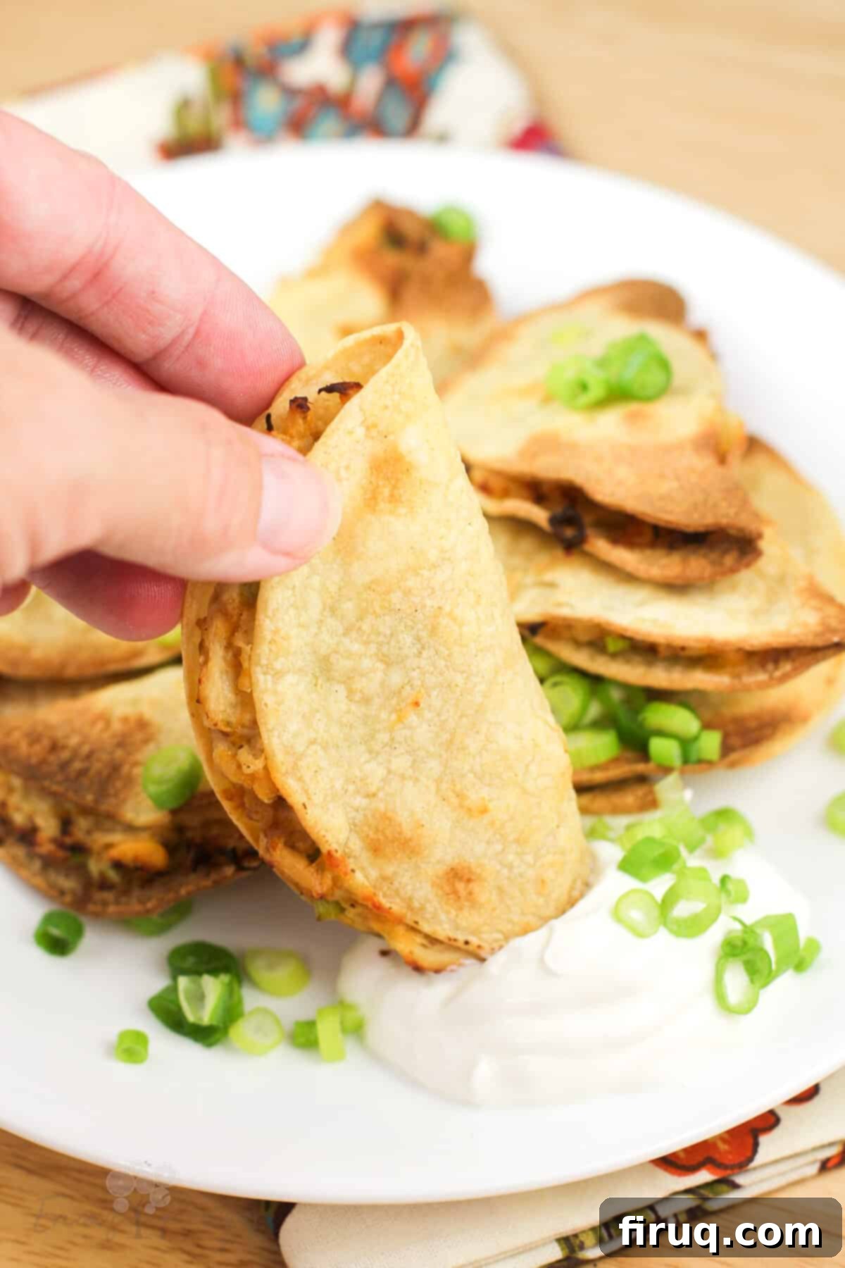 Crispy Mini Air Fryer Chicken Quesadilla 7 hand dipping quesadilla into sour cream