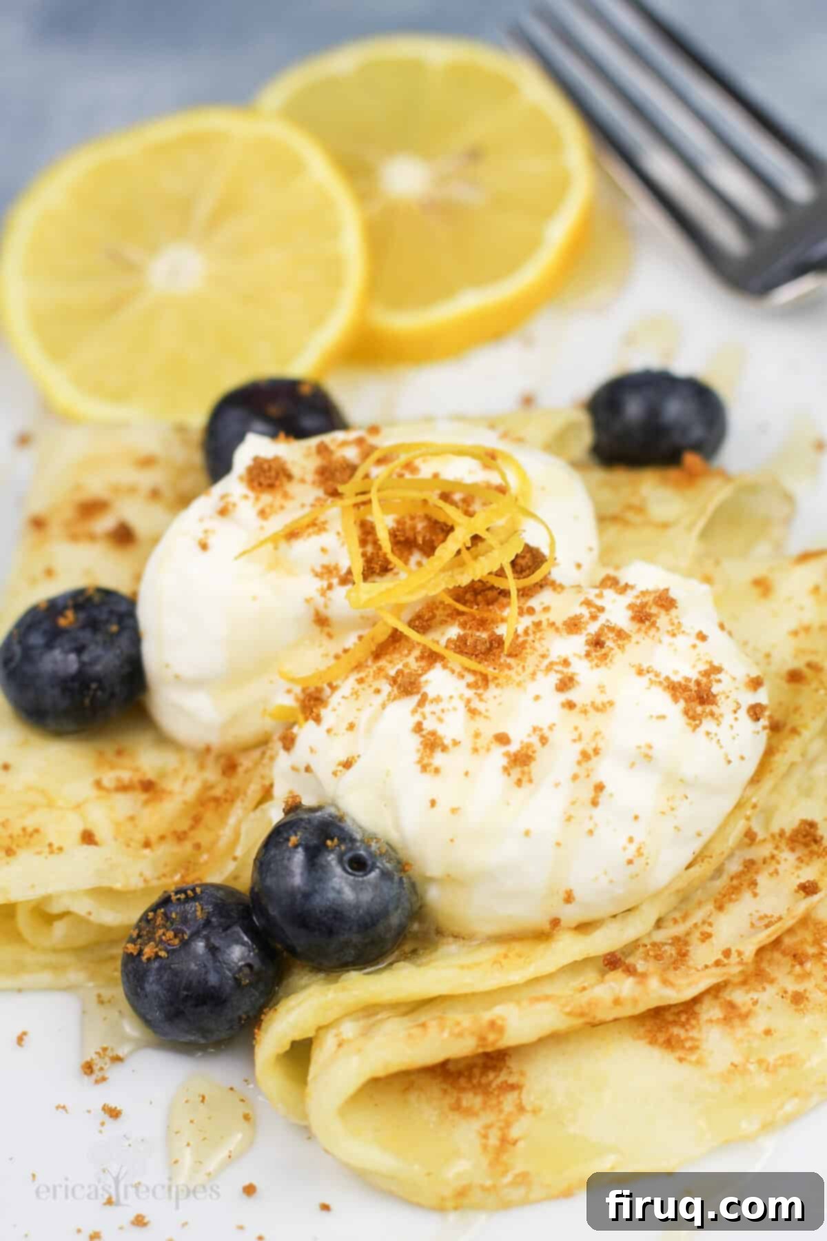 Zesty Lemon Crepes with Cloud Mascarpone 3 Lemon mascarpone and fresh blueberries artfully arranged on top of perfectly folded lemon crepes on a white plate