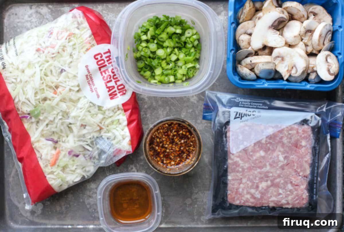 Blackstone Egg Roll Bowl 4 prepped ingredients for egg roll in a bowl assembled on a rimmed baking sheet, ready for cooking
