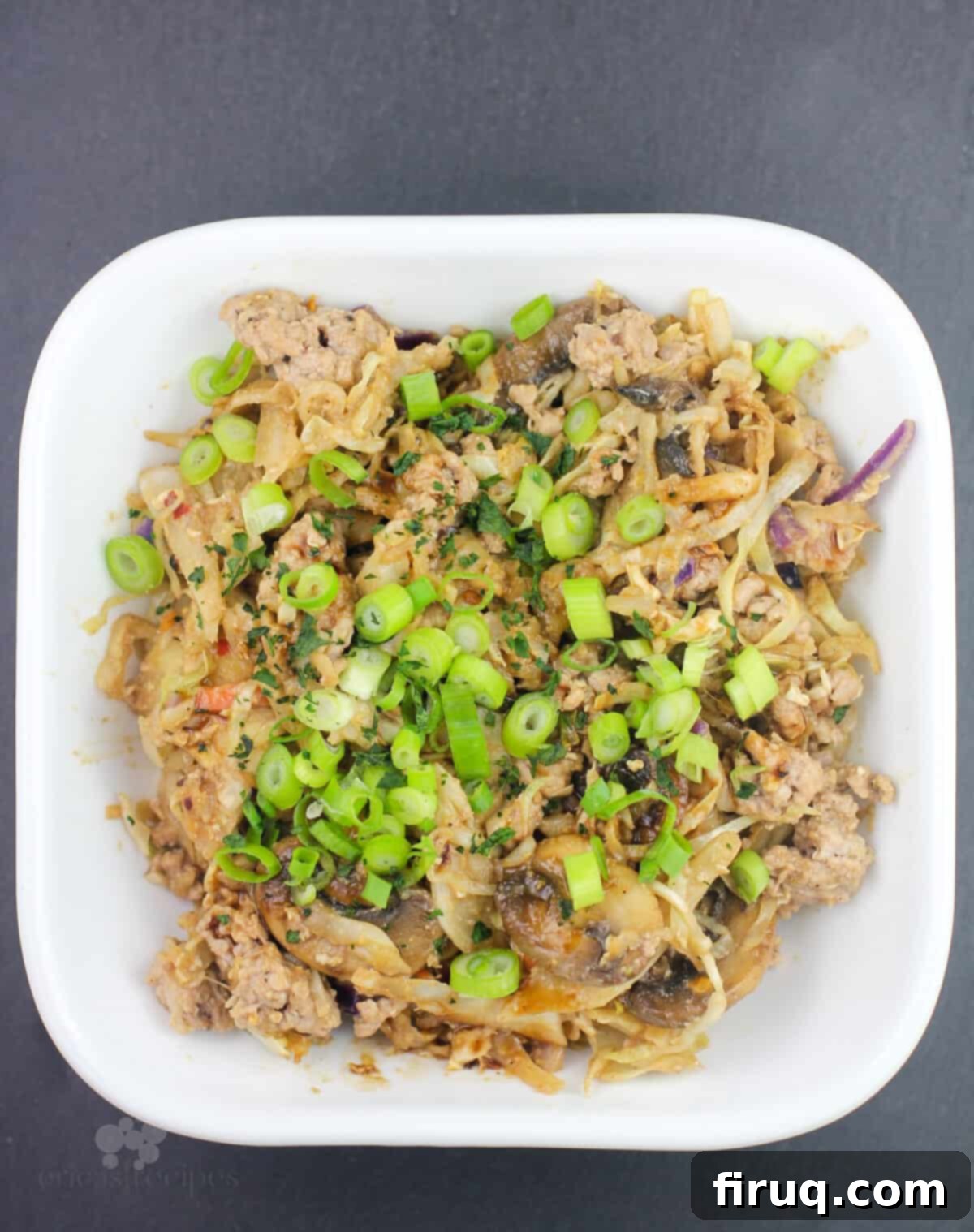 Blackstone Egg Roll Bowl 8 prepared recipe in a white bowl, garnished with green onions and ready to eat