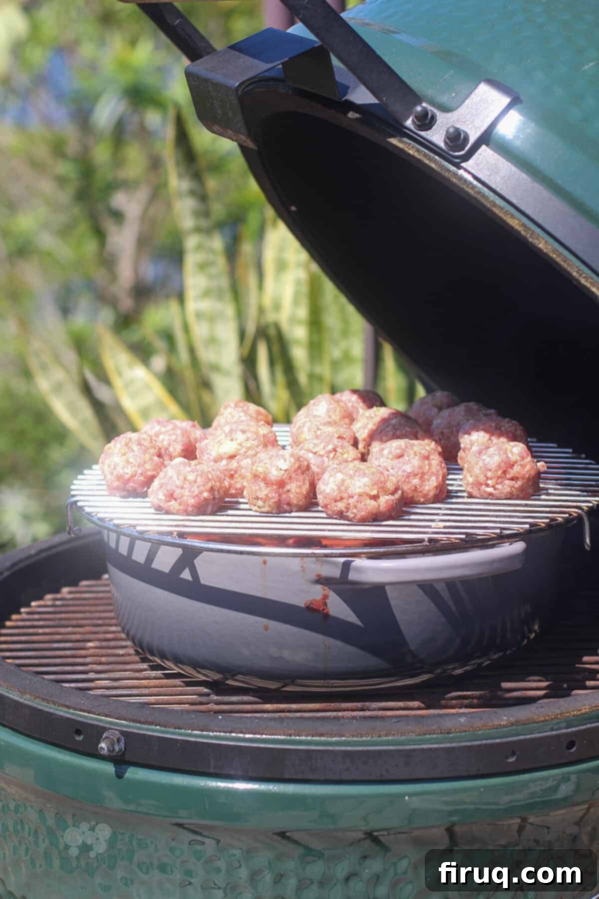Smoky Meatballs in Tangy Marinara 6 uncooked meatballs on rack on dutch oven in big green egg (side view)