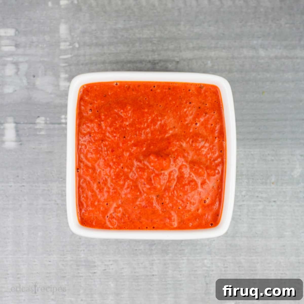 Roasted Red Pepper Coulis 2 red pepper coulis in small square white bowl on gray rustic surface