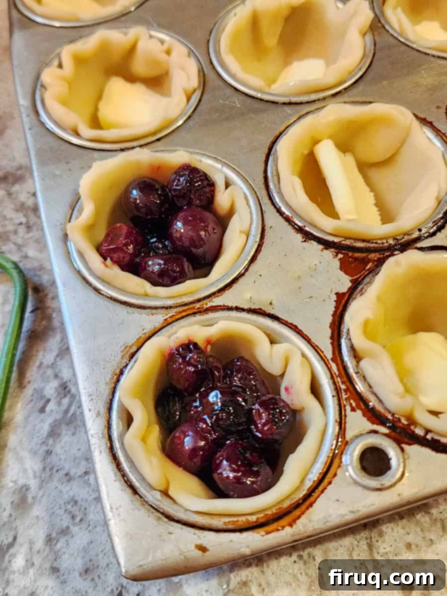 Sweet & Creamy Blueberry Brie Bites 3 muffin tin with prepared pie crust and filling before baking