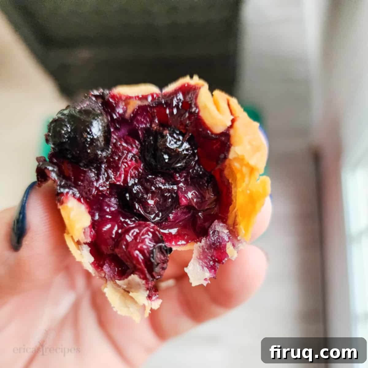 Sweet & Creamy Blueberry Brie Bites 6 hand holding a prepared pie bite