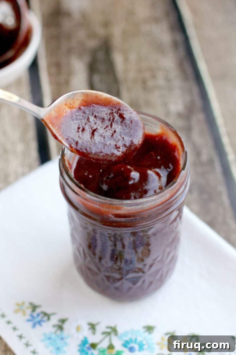 Sweet Heat Cherry Chipotle BBQ 3 spoon in a mason jar with barbecue sauce