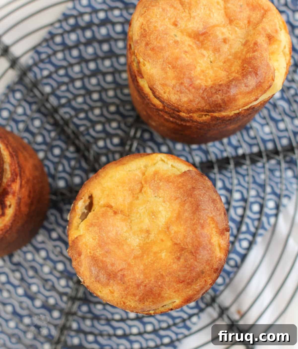 Garlic Parmesan Puffs 4 top down view of 3 popovers on wire rack over blue napkin