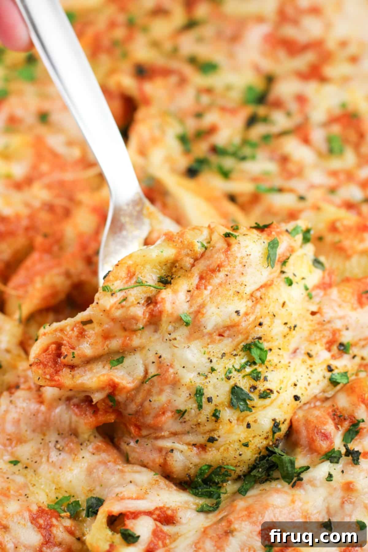 Zesty Cajun Shrimp and Crab Stuffed Shells with Creamy Vodka Sauce 2 A spatula lifting a perfectly baked Cajun Shrimp and Crab Stuffed Shell from a casserole dish, showcasing the rich, creamy vodka sauce and melted cheese.